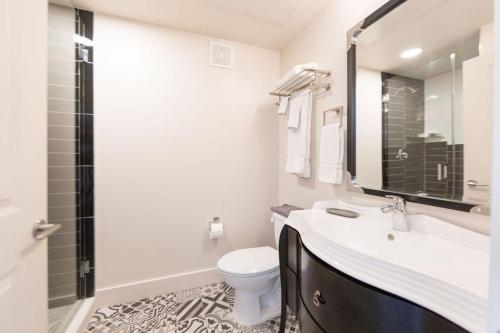a white bathroom with a sink and a toilet at The Bishop Arts Hotel by Qresorts in Dallas