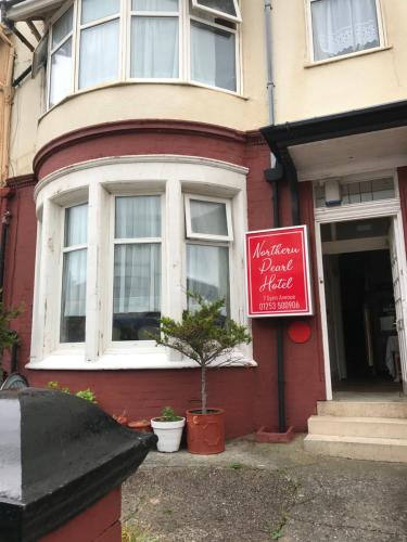 a red building with a sign in front of it at Northern Pearl Hotel in Blackpool