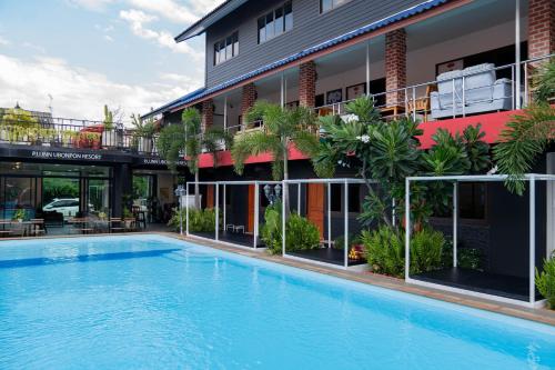 a large swimming pool in front of a building at P.U. Inn Resort in Phra Nakhon Si Ayutthaya