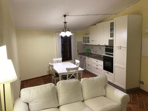a living room with a white couch and a table at Rosa di Maggio in Pari
