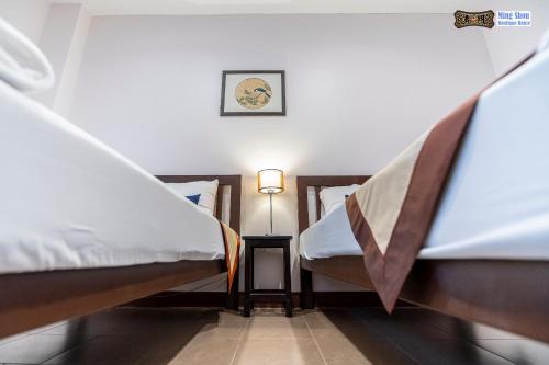 a room with two beds and a lamp on a table at Ming Shou Boutique House in Phuket Town