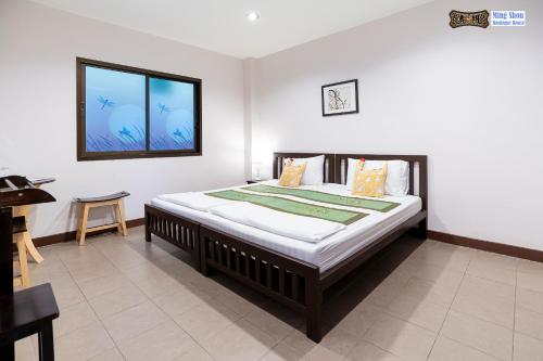 a bedroom with a large bed with a window at Ming Shou Boutique House in Phuket Town