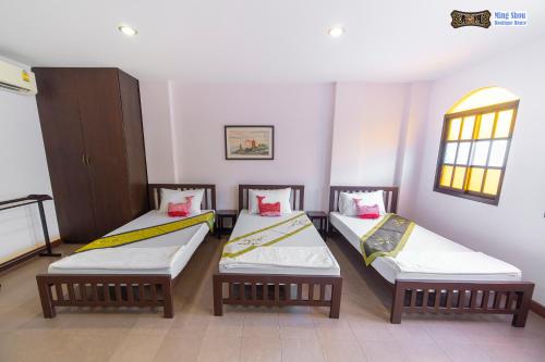 a room with three twin beds in it at Ming Shou Boutique House in Phuket Town