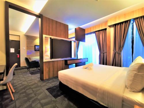 a hotel room with a bed and a flat screen tv at Prestigo Hotel - Johor Bharu in Johor Bahru