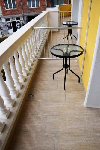 a staircase with two tables and a glass table at MARIANA - guest rooms in Gotse Delchev