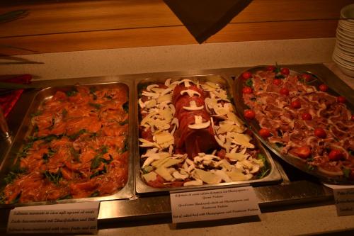 three trays of pizzas on display on a table at Eraclea Palace Hotel 4 stelle S in Eraclea Mare