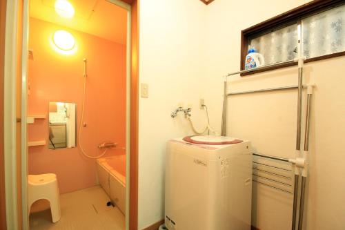 uma pequena casa de banho com um lavatório e um frigorífico em kODATEL コダテル函館ウエストサイド em Hakodate