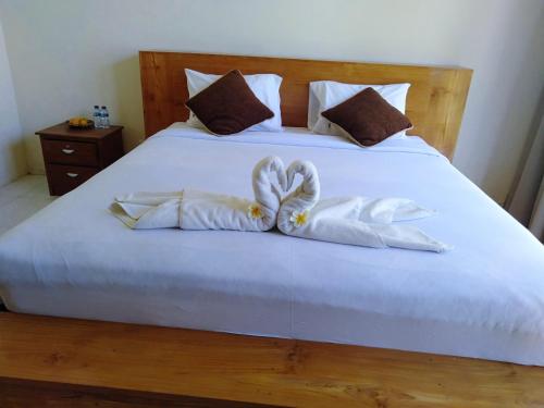 a white bed with two white towels on it at Segara Healing Villa in Kintamani