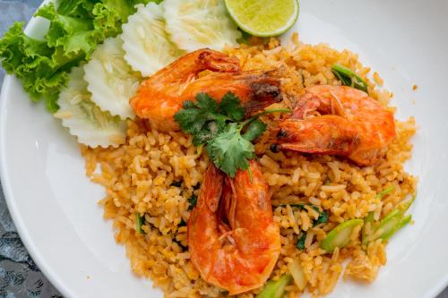 a white plate of food with shrimp and rice at Sky Hip Resort - SHA Certified in Jomtien Beach