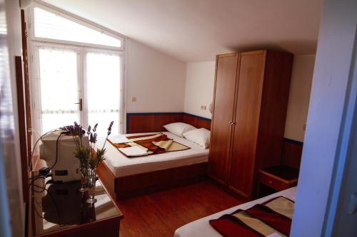 a small room with a bed and a cabinet at Beach Hotel in Drasnice