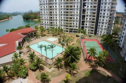 una vista sul tetto di una piscina con palme e edifici di BayView Villa Condominium Apartment A a Kampong Baharu