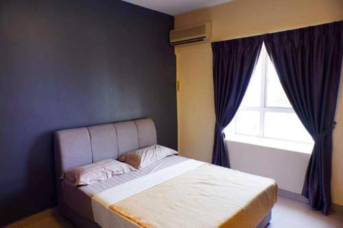 um quarto com uma cama grande e uma janela em BayView Villa Condominium Apartment A em Kampong Baharu