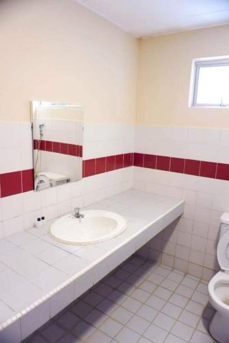 uma casa de banho com um lavatório e um WC em BayView Villa Condominium Apartment A em Kampong Baharu