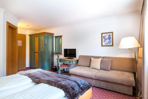 a hotel room with a bed and a couch at Kertess in Sankt Anton am Arlberg
