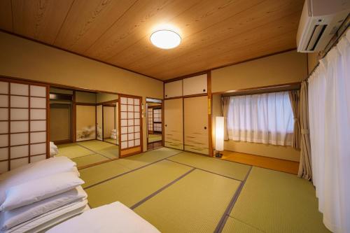 a japanese room with a bed and a window at Yufu-no-yu Shiki Iyashi in Yufuin