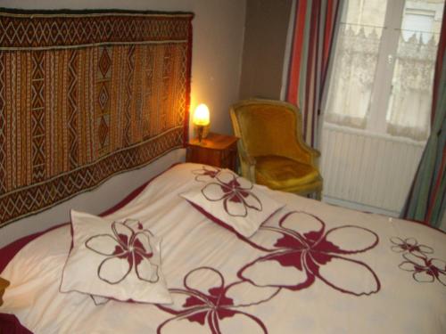 a bedroom with a bed with red flowers on it at Le Beaupassant in Vihiers