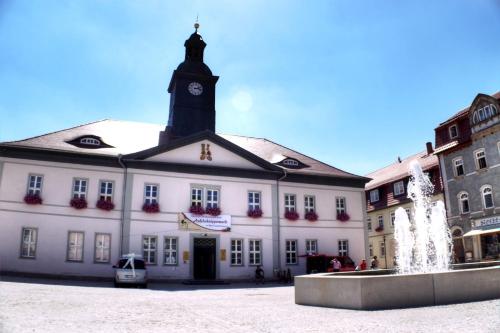 a large white building with a clock tower at Hotel-Restaurant Thüringer Hof in Bad Frankenhausen