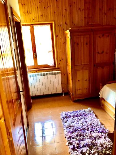a bedroom with a bed and a purple rug on the floor at Chalet dell'Orso in Pescasseroli