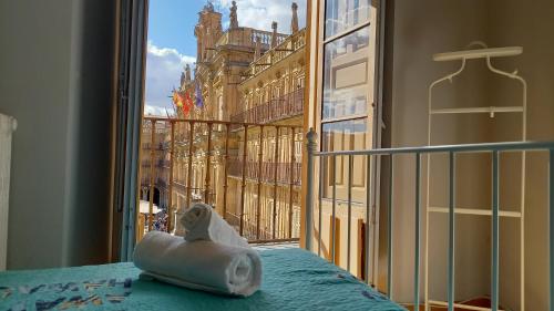 a towel animal sitting on a bed in front of a window at Plaza Mayor 7, 2º - Único en la Plaza Mayor! in Salamanca