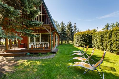 a group of chairs sitting outside of a house at Sodyba Brazylija in Taraldžiai