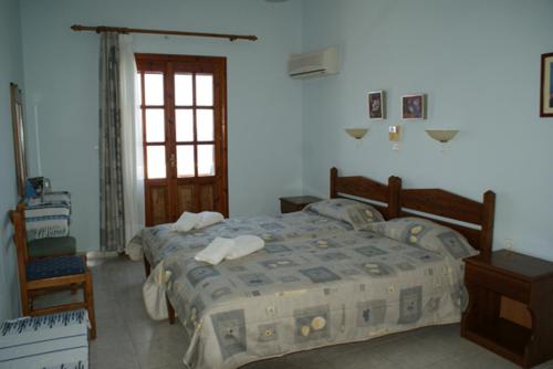 A bed or beds in a room at Pension Akropolis