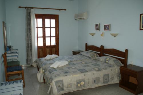 1 Schlafzimmer mit 2 Betten und einem Fenster in der Unterkunft Pension Akropolis in Kyra Panagia