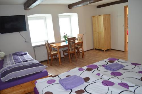 a bedroom with a bed and a table with chairs at Apartmány Kosmonosy, Hradištská 181 in Mladá Boleslav