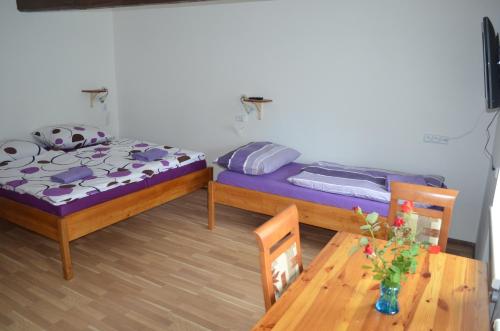 two beds in a room with a table and chairs at Apartmány Kosmonosy, Hradištská 181 in Mladá Boleslav