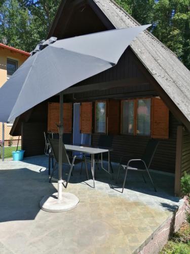 a large white umbrella in front of a house at Fábián Apartman in Tata