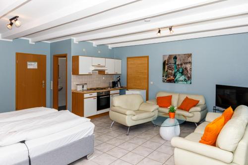uma sala de estar com uma cama e uma cozinha em Apart Hotel Sarstedter Hof em Sarstedt