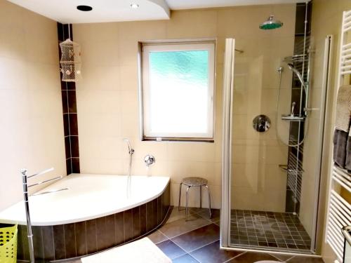 La salle de bains est pourvue d'une baignoire, d'une douche et d'une fenêtre. dans l'établissement Ferienwohnung Erni, à Feldkirchen in Kärnten