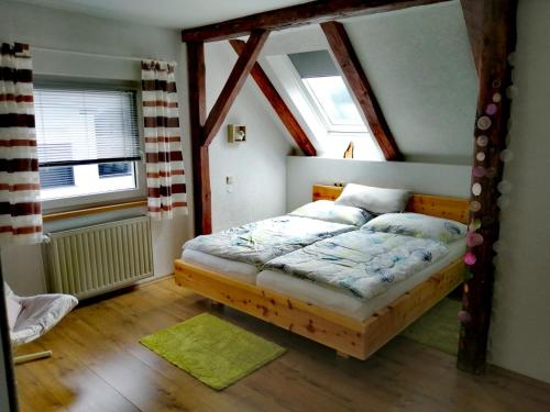 - une chambre avec un lit doté d'un cadre en bois dans l'établissement Ferienwohnung Erni, à Feldkirchen in Kärnten