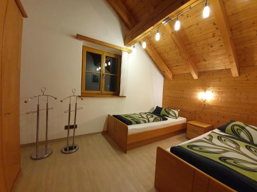 a bedroom with two beds in a wooden cabin at Ferienwohnung am Kneipp-Park in Scheidegg