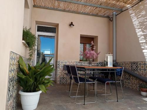 a patio with a table and chairs and plants at Casa Rural Rectoría de Raspay in Raspay