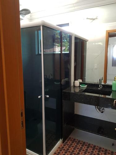 a bathroom with a glass shower and a sink at Luxury Duplex Casa in Natal