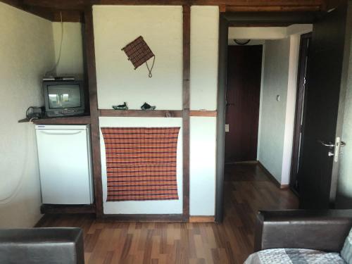 a room with a kitchen and a television and a door at Александрова вила 1 in Zlatograd