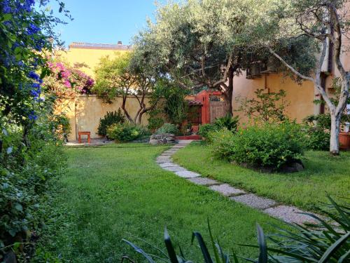 einen Garten mit einem Weg zum Haus in der Unterkunft B&B Dimora Degli Ulivi in Muravera