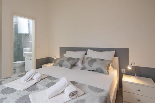 a bedroom with a large white bed with pillows at Holiday Resort Balota in Viganj