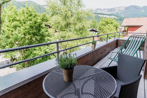 a table and chairs on a balcony with a view at Wohlfühlhotel Goiserer Mühle in Bad Goisern