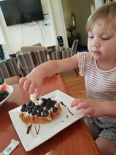 a young child sitting at a table with a plate of food at Quality Hotel Regent Rockhampton in Rockhampton