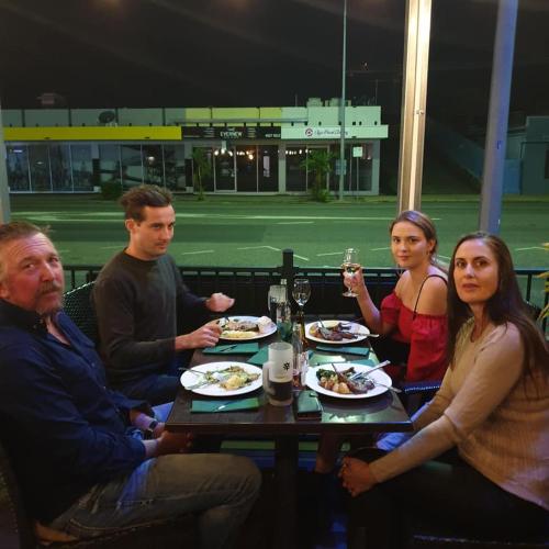 a group of people sitting around a table eating food at Quality Hotel Regent Rockhampton in Rockhampton