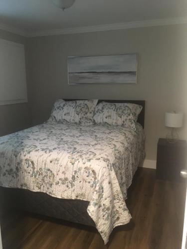 a bedroom with a bed with a comforter at Quidi Vidi Retreat 3 in St. John's