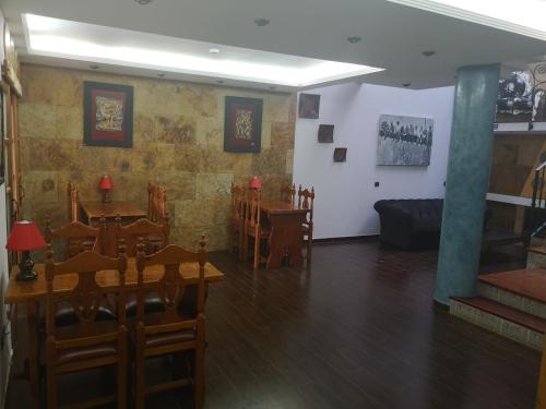 a dining room with tables and chairs and a couch at La Casona Canaria Boutique Home B & B in Agüimes