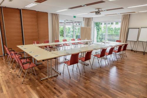 duża sala konferencyjna z długim stołem i krzesłami w obiekcie Wohlfühlhotel Goiserer Mühle w mieście Bad Goisern