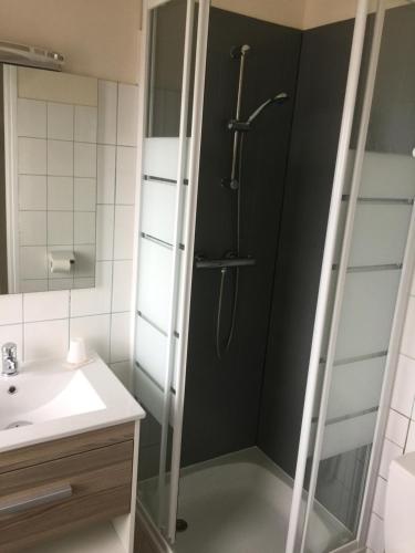 um chuveiro com uma porta de vidro na casa de banho em Hotel TGV em Quimper