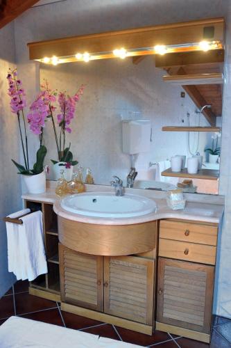 a bathroom with a sink and flowers on a counter at Hotel Vittoria in Premeno