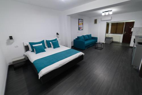 una camera con un grande letto e un divano blu di Aviator Apartament - Business Class Confort - Luxury a Deva