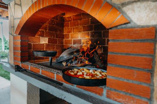 a brick oven with a pan of food in it at Apartman Vesna in Kupres