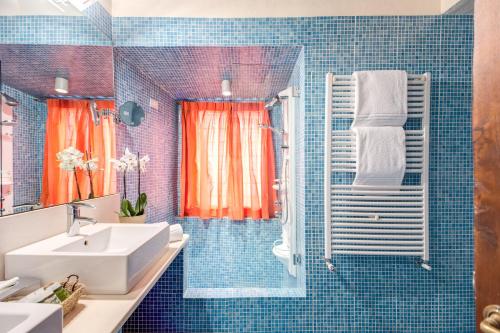 een blauwe betegelde badkamer met een wastafel en een douche bij Residenza Torre Colonna in Rome
