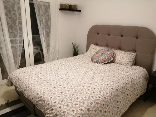 a bed with a headboard and two pillows on it at Sable Blanc Apartments in Ixia